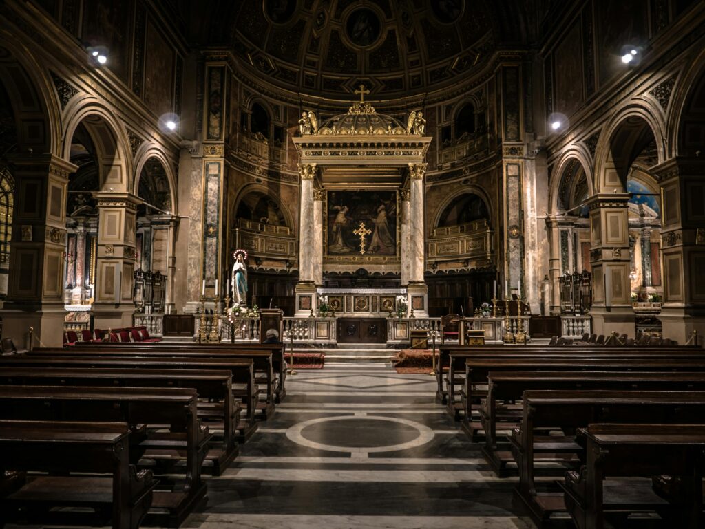 Interior view of a Gothic-style basilica in Rome, showcasing intricate architecture and religious art.